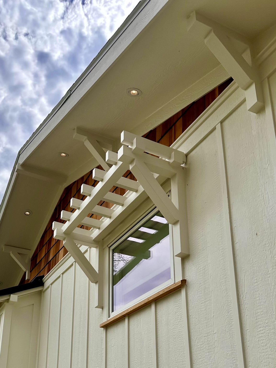 Close view of custom exterior brackets and a small window arbor