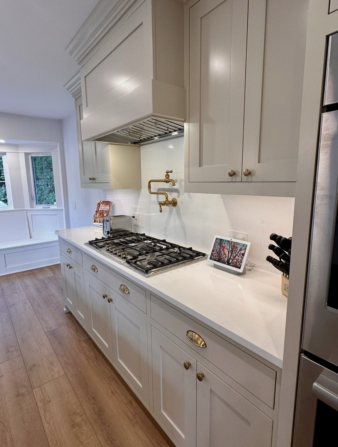 Custom inset cabinetry, cooktop and brass pot filler