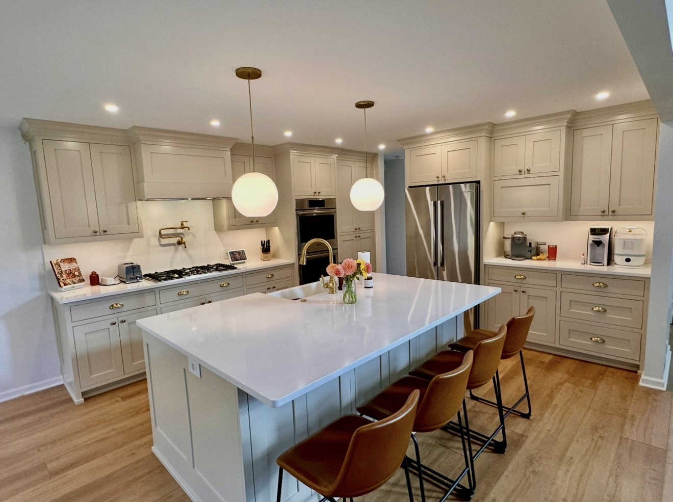 Full custom kitchen with large island, inset cabinetry and warm wood floors