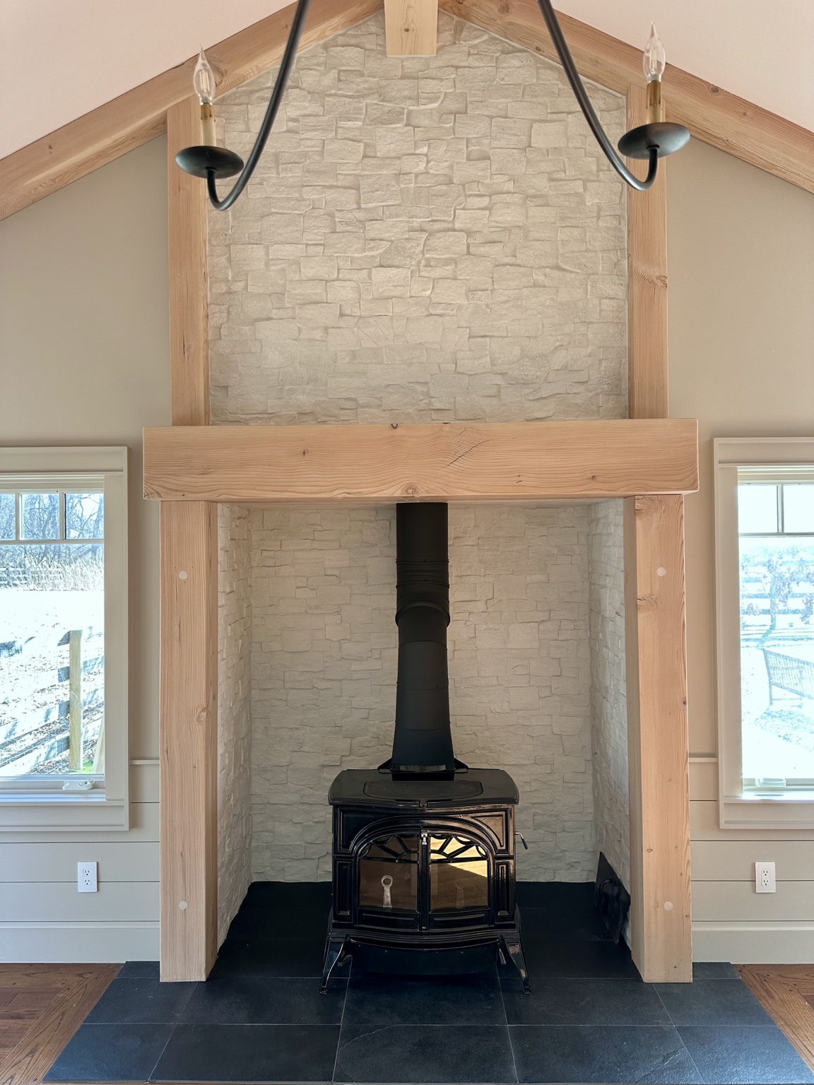 Stone fireplace framed with natural timber and a handcrafted wood mantel